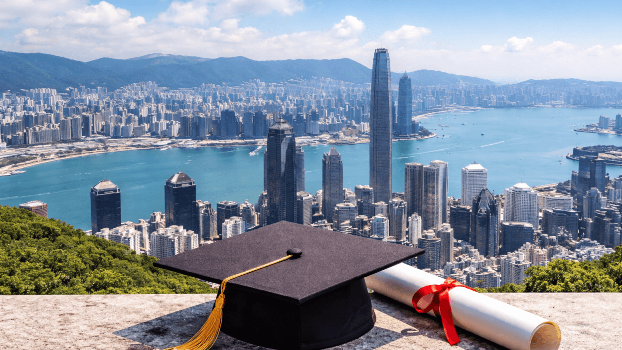 Graduation cap and diploma overlooking the Hong Kong skyline and Victoria Harbour